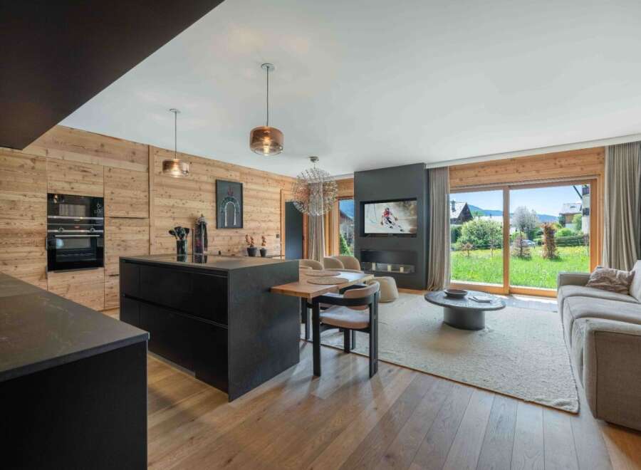 Experience luxury living in this stunning property featuring a modern kitchen with sleek black cabinetry and a spacious island.