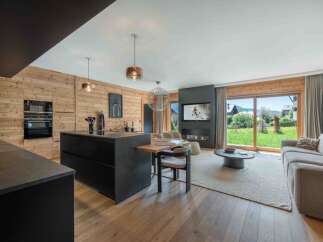 Experience luxury living in this stunning property featuring a modern kitchen with sleek black cabinetry and a spacious island.