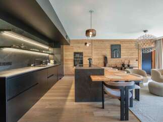 Experience modern luxury in this stunning kitchen, featuring sleek black cabinetry and a contrasting wooden accent wall.