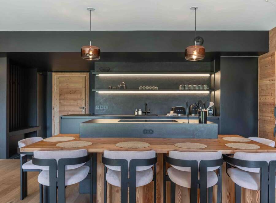 This modern kitchen boasts a sleek design with dark cabinetry and a spacious island, perfect for both cooking and entertaining.