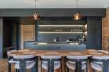 This modern kitchen boasts a sleek design with dark cabinetry and a spacious island, perfect for both cooking and entertaining.