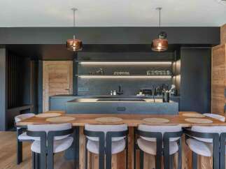 This modern kitchen boasts a sleek design with dark cabinetry and a spacious island, perfect for both cooking and entertaining.