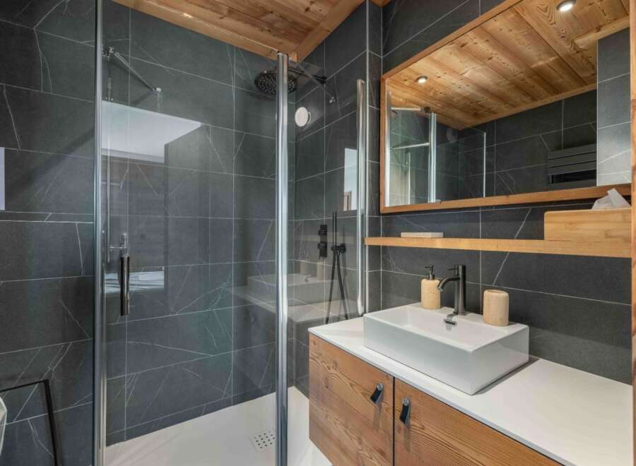 This modern bathroom showcases a sleek design with a spacious walk-in shower and a stylish vanity.