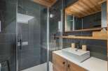 This modern bathroom showcases a sleek design with a spacious walk-in shower and a stylish vanity.