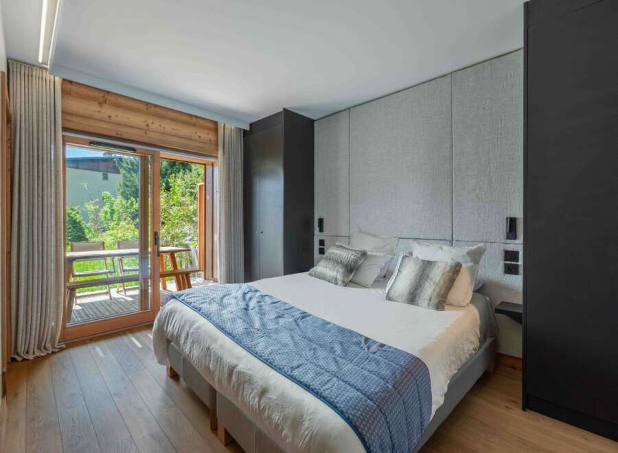 Experience luxury in this stunning bedroom featuring a king-size bed, elegant headboard, and a private balcony.