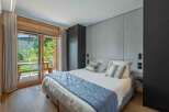 Experience luxury in this stunning bedroom featuring a king-size bed, elegant headboard, and a private balcony.