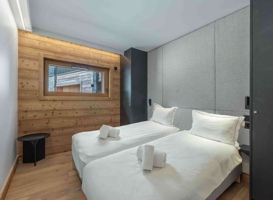 This cozy bedroom features two twin beds with crisp white linens and plush pillows, perfect for a comfortable stay.