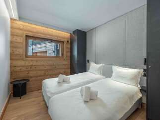 This cozy bedroom features two twin beds with crisp white linens and plush pillows, perfect for a comfortable stay.
