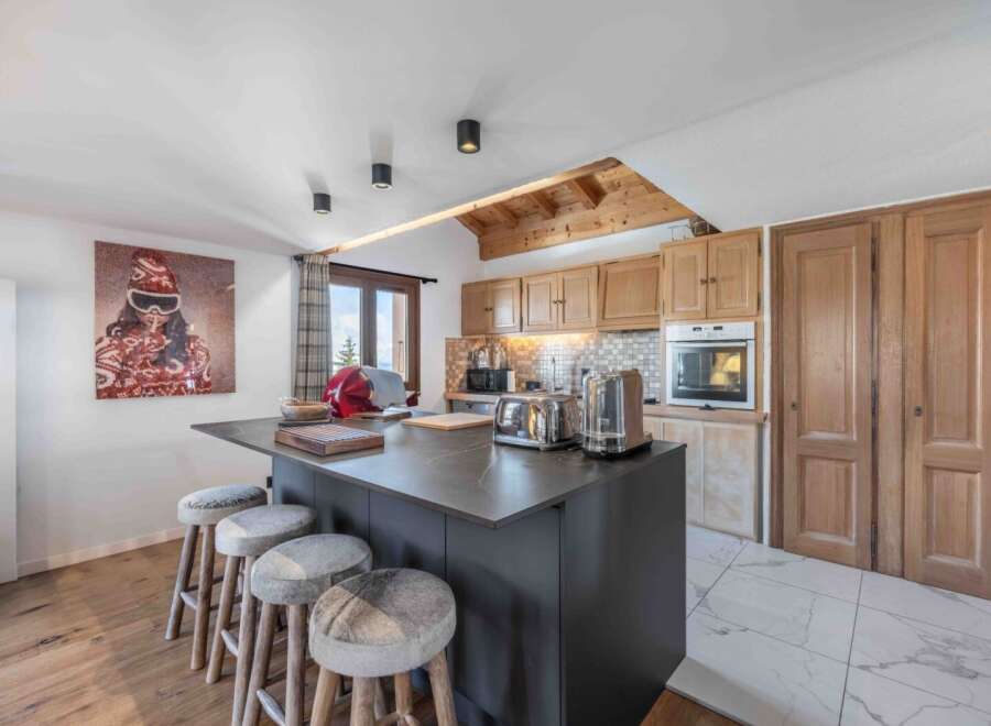 This stunning kitchen boasts a modern design with a sleek island and stylish bar stools, perfect for entertaining.