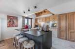 This stunning kitchen boasts a modern design with a sleek island and stylish bar stools, perfect for entertaining.