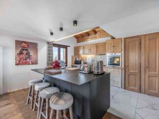This stunning kitchen boasts a modern design with a sleek island and stylish bar stools, perfect for entertaining.