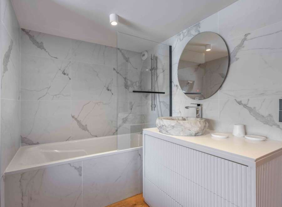 Step into a luxurious bathroom oasis, featuring stunning marble-effect tiles that exude elegance.