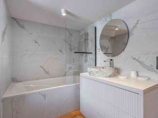 Step into a luxurious bathroom oasis, featuring stunning marble-effect tiles that exude elegance.