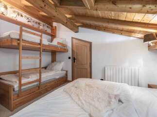 This cozy bedroom features a unique bunk bed setup, perfect for families or groups.