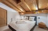 Experience rustic charm in this cozy bedroom featuring a stunning wooden ceiling and exposed beams.