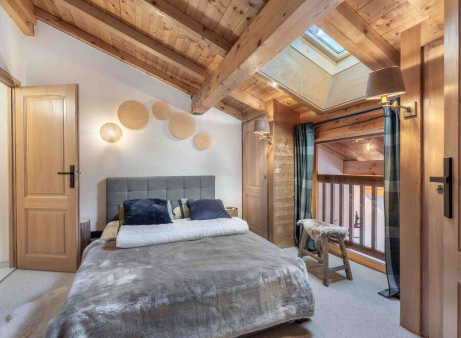 Experience the charm of this cozy bedroom featuring a rustic wooden ceiling and walls, creating a warm and inviting atmosphere.