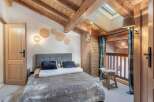 Experience the charm of this cozy bedroom featuring a rustic wooden ceiling and walls, creating a warm and inviting atmosphere.