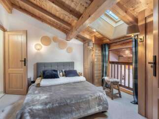Experience the charm of this cozy bedroom featuring a rustic wooden ceiling and walls, creating a warm and inviting atmosphere.