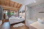 Experience luxury in this stunning bedroom featuring a cozy bed, a plush rug, and a beautiful view.