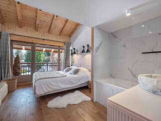 Experience luxury in this stunning bedroom featuring a cozy bed, a plush rug, and a beautiful view.