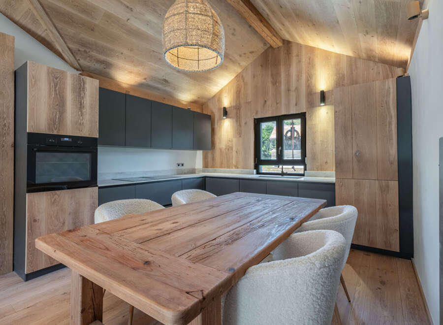 This stunning kitchen boasts a rustic charm with its wooden ceiling and cabinetry, creating a warm and inviting atmosphere.