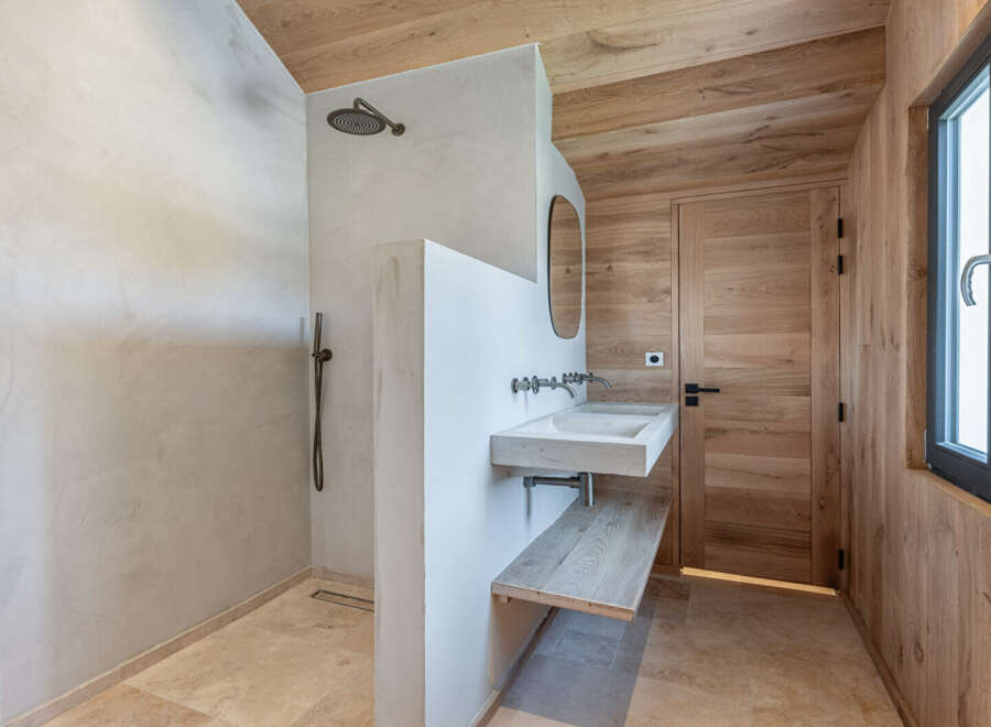 This stunning bathroom boasts a modern design with natural wood accents, creating a warm and inviting atmosphere.