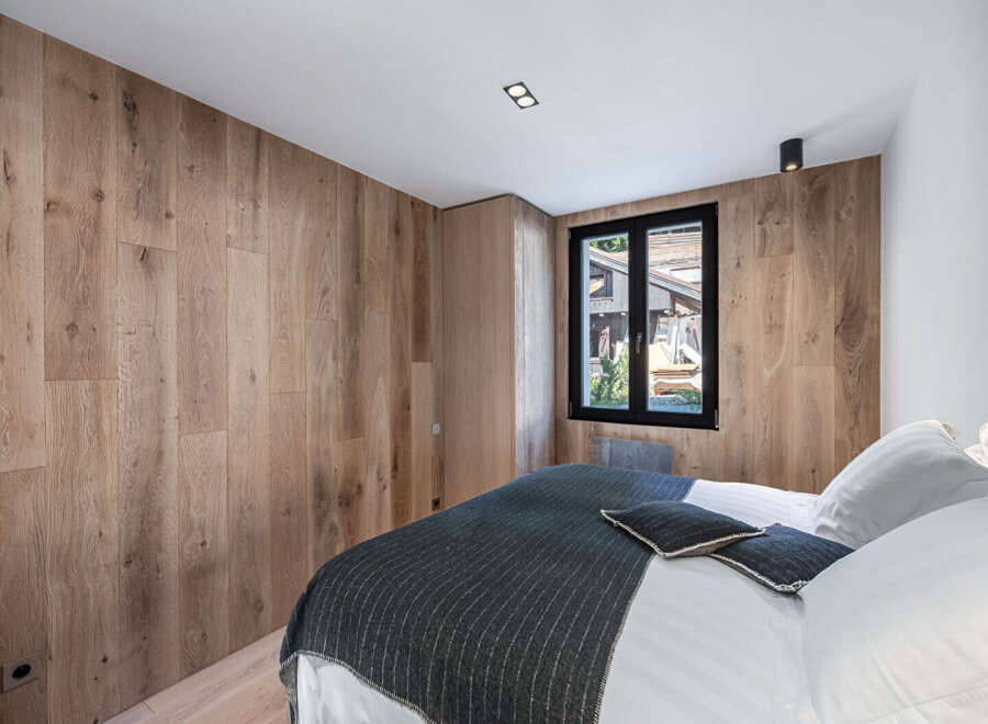 This stunning bedroom boasts a modern design with beautiful wooden paneling that adds warmth and character.