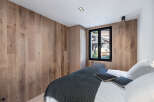 This stunning bedroom boasts a modern design with beautiful wooden paneling that adds warmth and character.