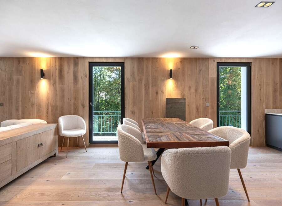 This stunning property boasts a modern dining area with a beautiful wooden table and comfortable chairs, perfect for hosting gatherings.
