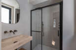 Step into a modern bathroom oasis, featuring a sleek glass shower enclosure and a stylish stone sink.