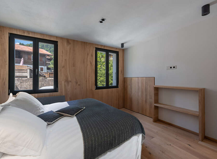 This stunning bedroom boasts a modern design with natural wood accents, creating a warm and inviting atmosphere.