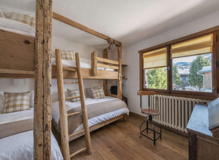 This charming bedroom features rustic wooden bunk beds, perfect for accommodating guests or family.