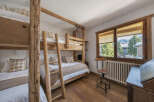 This charming bedroom features rustic wooden bunk beds, perfect for accommodating guests or family.