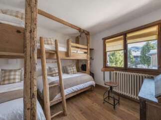 This charming bedroom features rustic wooden bunk beds, perfect for accommodating guests or family.
