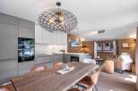 Experience luxury living in this stunning property, featuring a modern kitchen with sleek cabinetry and high-end appliances.