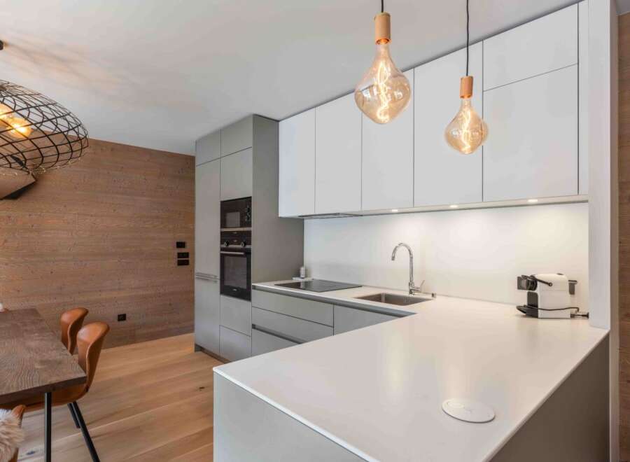 This modern kitchen boasts sleek cabinetry and a pristine countertop, perfect for culinary enthusiasts.