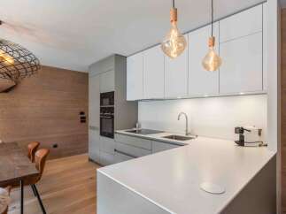 This modern kitchen boasts sleek cabinetry and a pristine countertop, perfect for culinary enthusiasts.