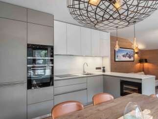 This modern kitchen boasts sleek cabinetry, stainless steel appliances, and a stunning geometric light fixture.