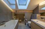 This modern bathroom boasts a unique design with a skylight that floods the space with natural light.