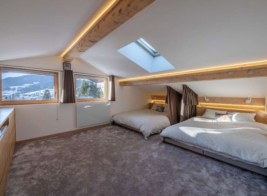 Discover the charm of this stunning bedroom, featuring a unique design with exposed wooden beams and a skylight.