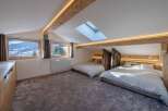 Discover the charm of this stunning bedroom, featuring a unique design with exposed wooden beams and a skylight.
