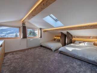Discover the charm of this stunning bedroom, featuring a unique design with exposed wooden beams and a skylight.