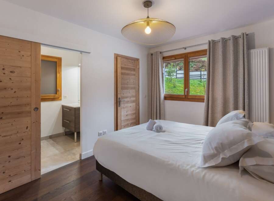 Discover the charm of this inviting bedroom, featuring a cozy bed and a stylish design.