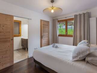 Discover the charm of this inviting bedroom, featuring a cozy bed and a stylish design.