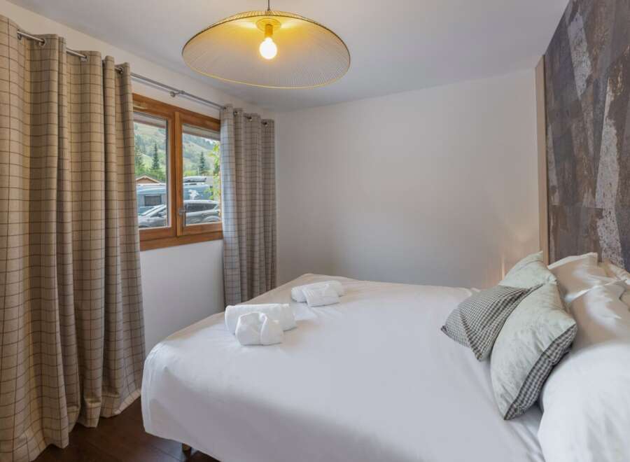 This cozy bedroom offers a serene retreat with its inviting ambiance and stylish design.
