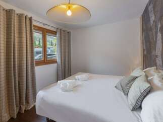 This cozy bedroom offers a serene retreat with its inviting ambiance and stylish design.
