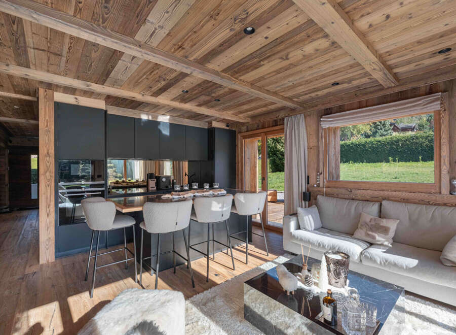 Experience luxury living in this stunning property featuring a modern kitchen with sleek black cabinetry and a breakfast bar.