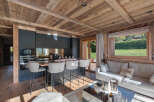 Experience luxury living in this stunning property featuring a modern kitchen with sleek black cabinetry and a breakfast bar.