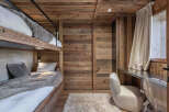 This cozy bedroom features a unique bunk bed design with wooden paneling, creating a warm and inviting atmosphere.