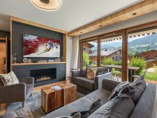 Experience luxury living in this stunning property, featuring a cozy living room with a fireplace and a large TV perfect for entertainment.
